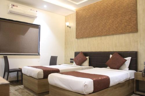 a hotel room with two beds and a tv at Hotel Sahyadri in Achād