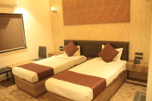 a hotel room with two beds in a room at Hotel Sahyadri in Achād