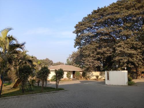 a house with a lot of trees and a street at Hotel Sahyadri in Achād