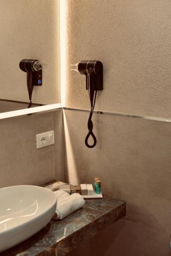 a bathroom with a sink and a phone on the wall at Palermo Inn Boutique Hotel in Palermo