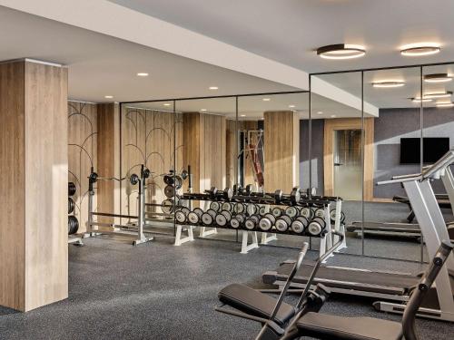a gym with a row of exercise equipment and mirrors at Mercure Sofia City in Sofia