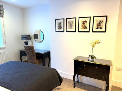 a bedroom with a bed and a desk with a mirror at 8 Crickhowell Cottages, Standard St, Central Crickhowell in Crickhowell