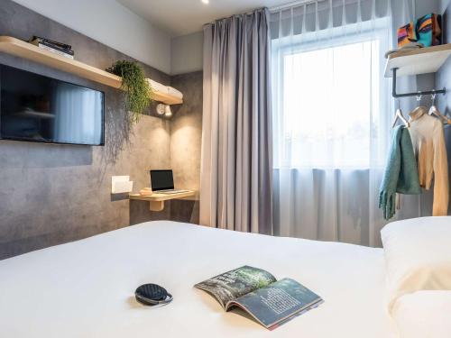 a bedroom with a bed with a book on it at ibis budget Arlon Porte du Luxembourg in Arlon
