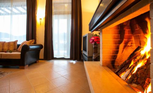 a living room with a fireplace and a couch at Holiday Village COOP Dobrinishte in Dobrinishte