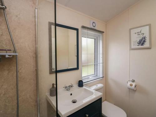 a bathroom with a sink and a glass shower at Lakeland Lodge- 3Bed-2 Bath- Private Patio in Carnforth
