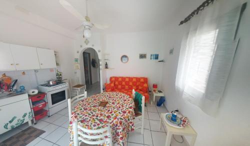 a kitchen with a table and a red couch in a room at Doria 18 in Lampedusa