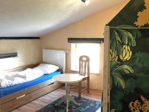 a bedroom with a bed and a table and a chair at Ferien auf dem Bauernhof Nr. 101 in Altenhagen