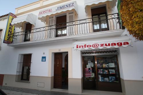 un edificio blanco con balcón y librería en Hostal Jiménez, en Azuaga