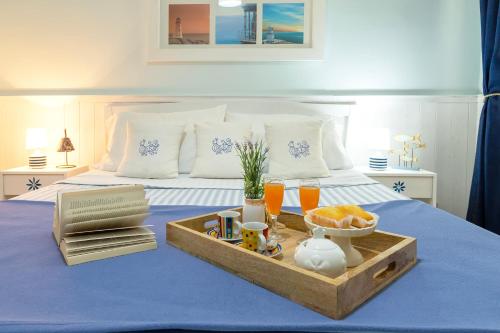 a bed with a tray of food and drinks on it at Appartamento degiorgio8 in Alghero
