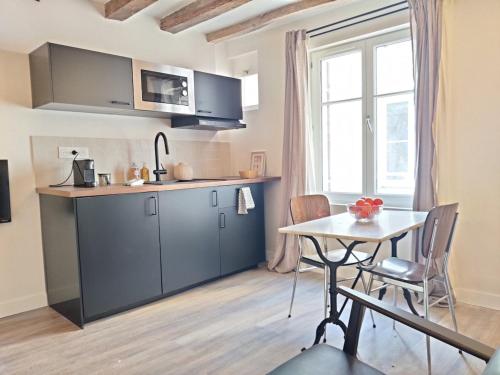 - une cuisine avec une table, une petite table, une table et des chaises dans l'établissement Cœur de Chinon, tout confort !, à Chinon