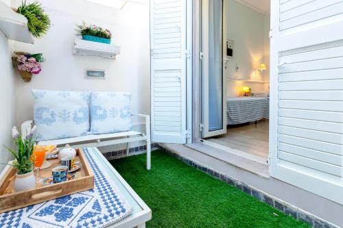 a porch with a bench and green grass at Appartamento degiorgio8 in Alghero