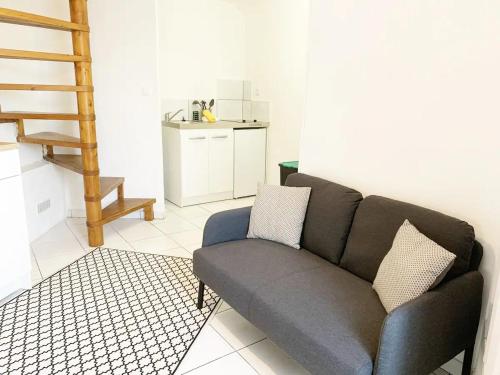 un salon avec un canapé et une cuisine dans l'établissement Duplex Le Coligny - Calme - Proche Centre Ville Poitiers, Patinoire, Université - CHU - Futuroscope à 20min, à Poitiers