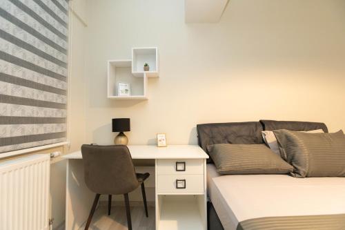a room with a bed and a desk and a couch at Urban Living in Gevgelija