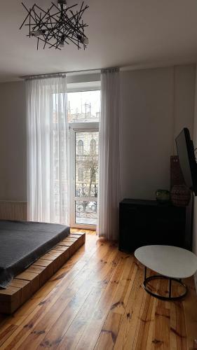 a bedroom with a bed and a table and a window at Smolynja stail in Ternopilʼ