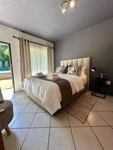 a bedroom with a large bed and a large window at Pass-through Apartments in Pretoria
