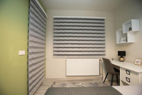 a room with a desk and a window with a radiator at Urban Living in Gevgelija
