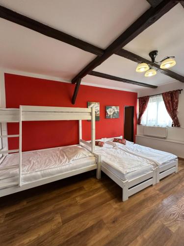 two bunk beds in a room with red walls at Penzion 4 Dvory in České Budějovice