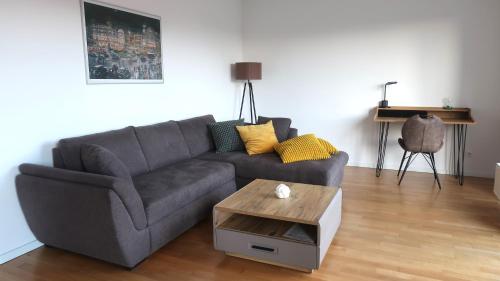 a living room with a gray couch and a coffee table at Hotel Spree-idyll in Berlin