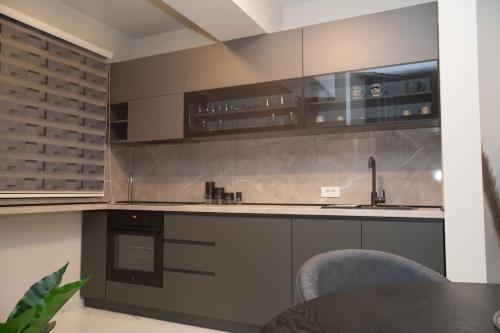 a kitchen with gray cabinets and a table and chairs at Urban Living in Gevgelija