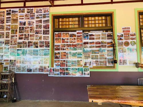 a wall with pictures on the side of a building at Cardamom Community Center in Moăt Preăh
