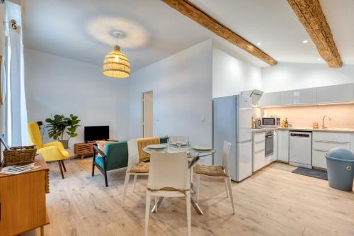 une cuisine et un salon avec une table et des chaises dans l'établissement Le Voltaire pour 4, à Sète