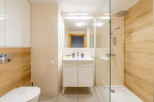 a bathroom with a shower and a sink and a toilet at Horyzont Apartamenty- Seaside Apartament prywatny z widokiem na morze in Kołobrzeg