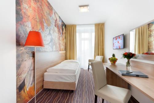 a hospital room with a bed and a desk at Akcent hotel in Prague