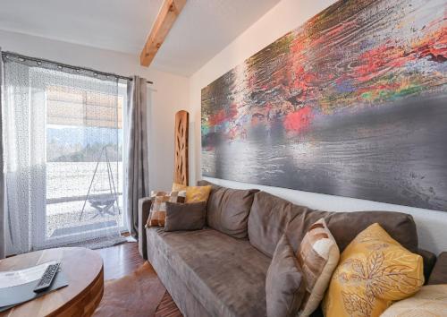 a living room with a couch and a large painting on the wall at Ferienbungalow Schlossblick in Füssen