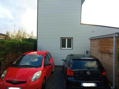 deux voitures garées devant une maison dans l'établissement Charmant cottage bord de mer camping 4 etoiles, à Hermanville-sur-Mer