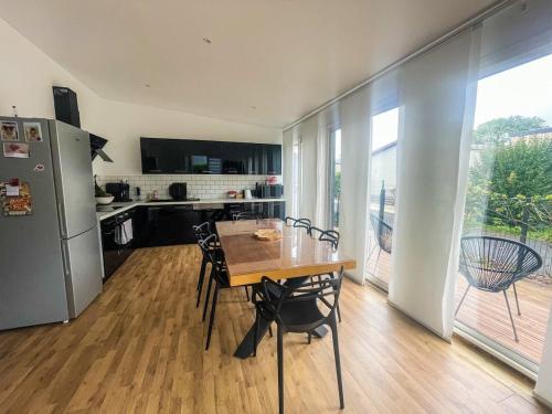 une cuisine avec une table, des chaises et un réfrigérateur dans l'établissement Charmant cottage bord de mer camping 4 etoiles, à Hermanville-sur-Mer
