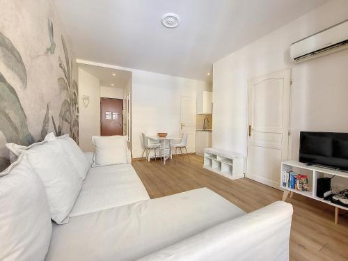 - un salon blanc avec un canapé blanc et une télévision dans l'établissement Nestor&Jeeves - SEA AND SUN - Central - Near Sea, à Nice