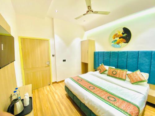 a bedroom with a large bed with a blue headboard at Park Plaza Hotel Near Golden Temple in Amritsar