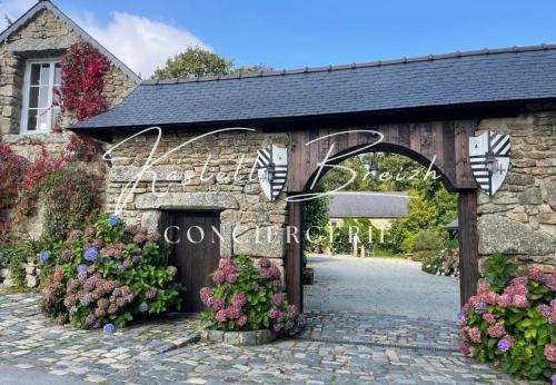 a stone entrance to a wedding venue with flowers at La familiale du manoir de Kerollivier in Saint-Gilles-Pligeaux