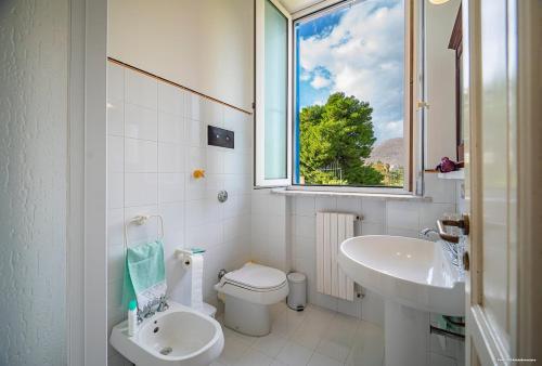 a bathroom with a toilet and a sink and a window at Sirene Blu in Palermo