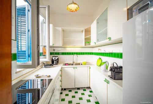 a kitchen with white cabinets and a checkered floor at Sirene Blu in Palermo