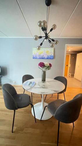 a dining room with a table and four chairs at Koselig leilighet med et skritt unna skibakken! in Kongsberg