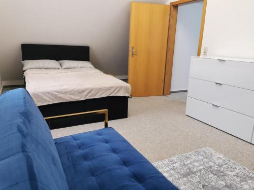 a bedroom with a bed and a blue couch at Lounge house in Burgau