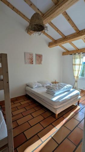 une chambre avec un lit dans une pièce avec des plafonds en bois dans l'établissement Villa provençale, clim et piscine, proche centre Vidauban, à Vidauban
