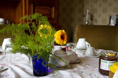 a blue vase filled with yellow flowers on a table at Locanda dei Buoni e Cattivi in Cagliari