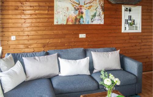 a blue couch with white pillows in a living room at Cozy Apartment In Sasbachwalden in Sasbachwalden