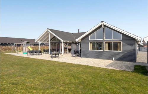 a gray house with a patio and a playground at Awesome Home In Sydals With Kitchen in Høruphav