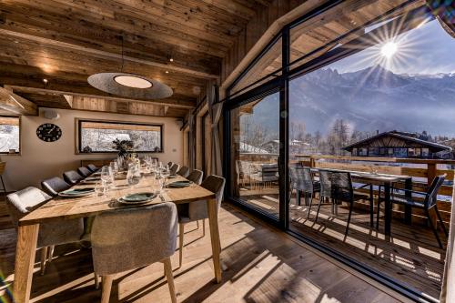 une salle à manger avec une table et une grande fenêtre dans l'établissement Chalet Josephine, Chamonix Les Bois, à Chamonix-Mont-Blanc