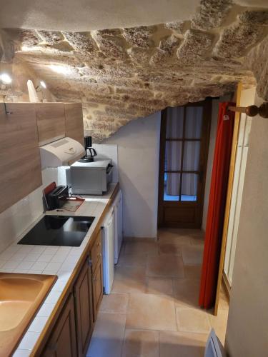 une cuisine avec un évier et un plan de travail dans l'établissement Maison en pierre au cœur de l'Ardèche avec 4 lits, 2 chambres, 1 piscine hors sol, à Planzolles