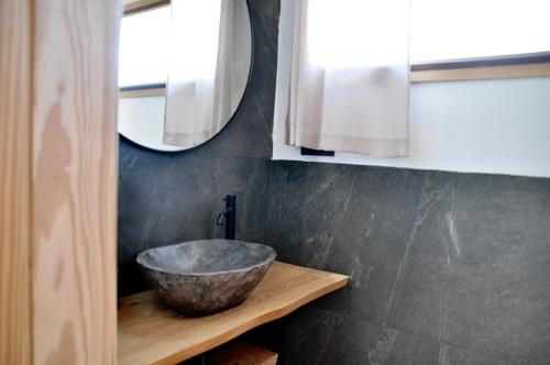 a bathroom with a bowl sink on a wooden shelf at Tindaya Nature Home Ocean View in Tindaya