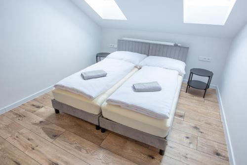 a bedroom with two beds and a black chair at Penzion Bistár in Habovka
