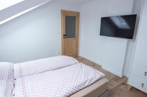 a bedroom with a bed and a flat screen tv at Penzion Bistár in Habovka