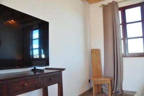 a living room with a television and a wooden chair at Tindaya Nature Home Ocean View in Tindaya