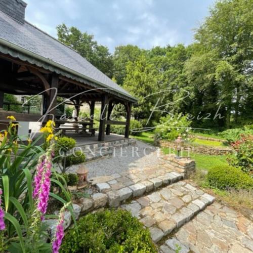 a garden with a gazebo and flowers at Le Cocon du manoir de Kerollivier in Saint-Gilles-Pligeaux