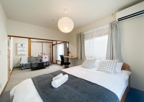 a bedroom with a large bed with white sheets at New Super Deals Now Available Direct Access to Akihabara Shinjuku and Disneyland in Tokyo