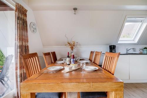 a wooden table in a kitchen with chairs and a tableablish at Kuifeend I Chalet met Modern Interieur in Zwiggelte